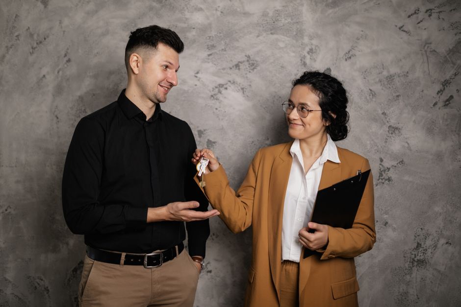Estate agent handing house keys to clients across a desk